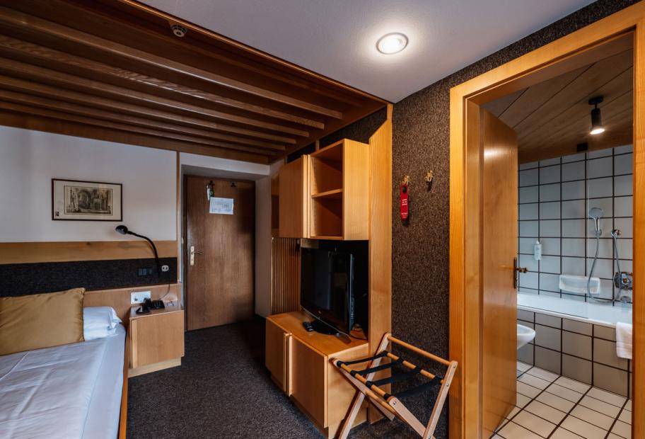 Camera d'albergo accogliente con bagno privato e arredamento in legno.