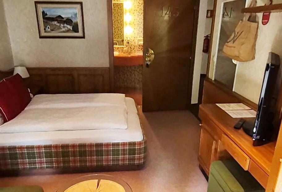 Camera d'albergo accogliente con letto matrimoniale, bagno privato e TV.