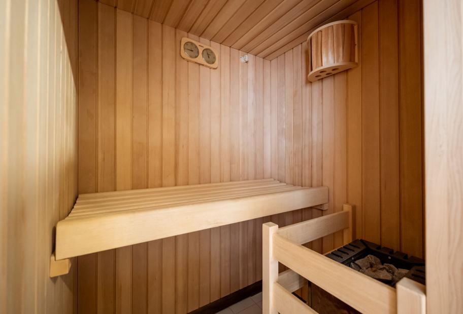 Una sauna in legno con panca e stufa a pietre.