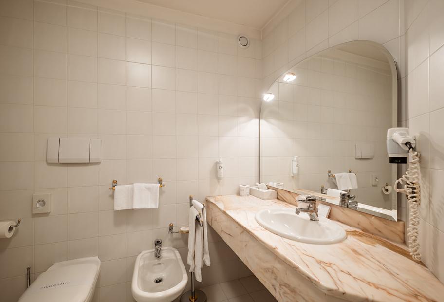 Bagno moderno con bidet, lavabo e asciugacapelli.